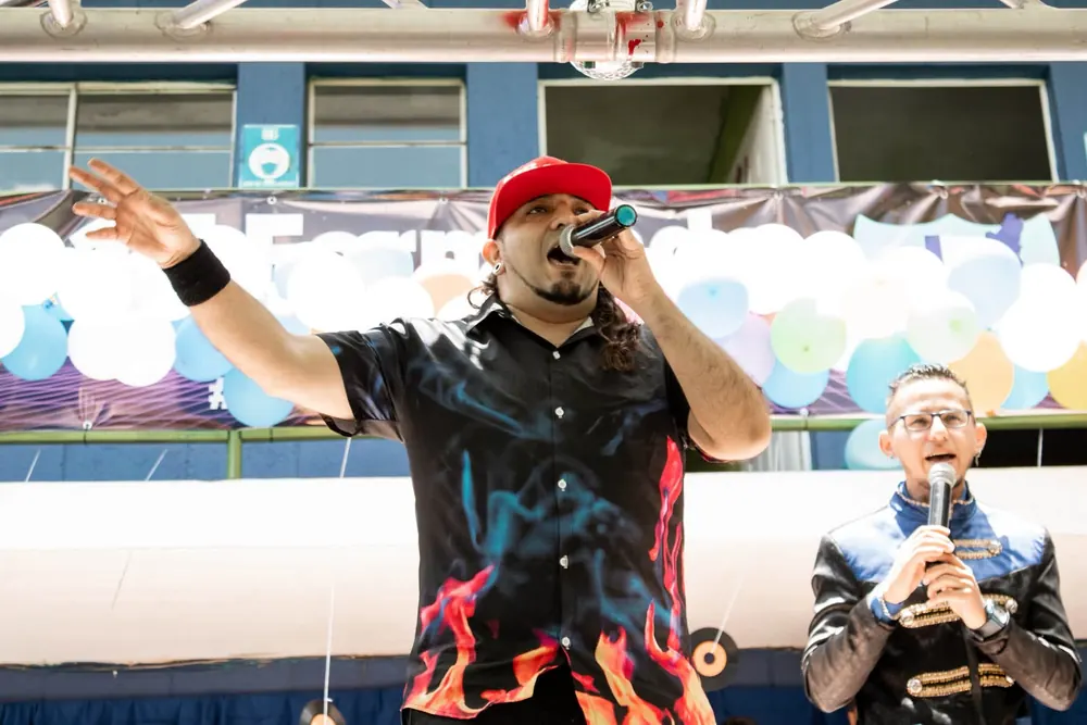 Invitado cantando con micrófono durante un evento en el colegio